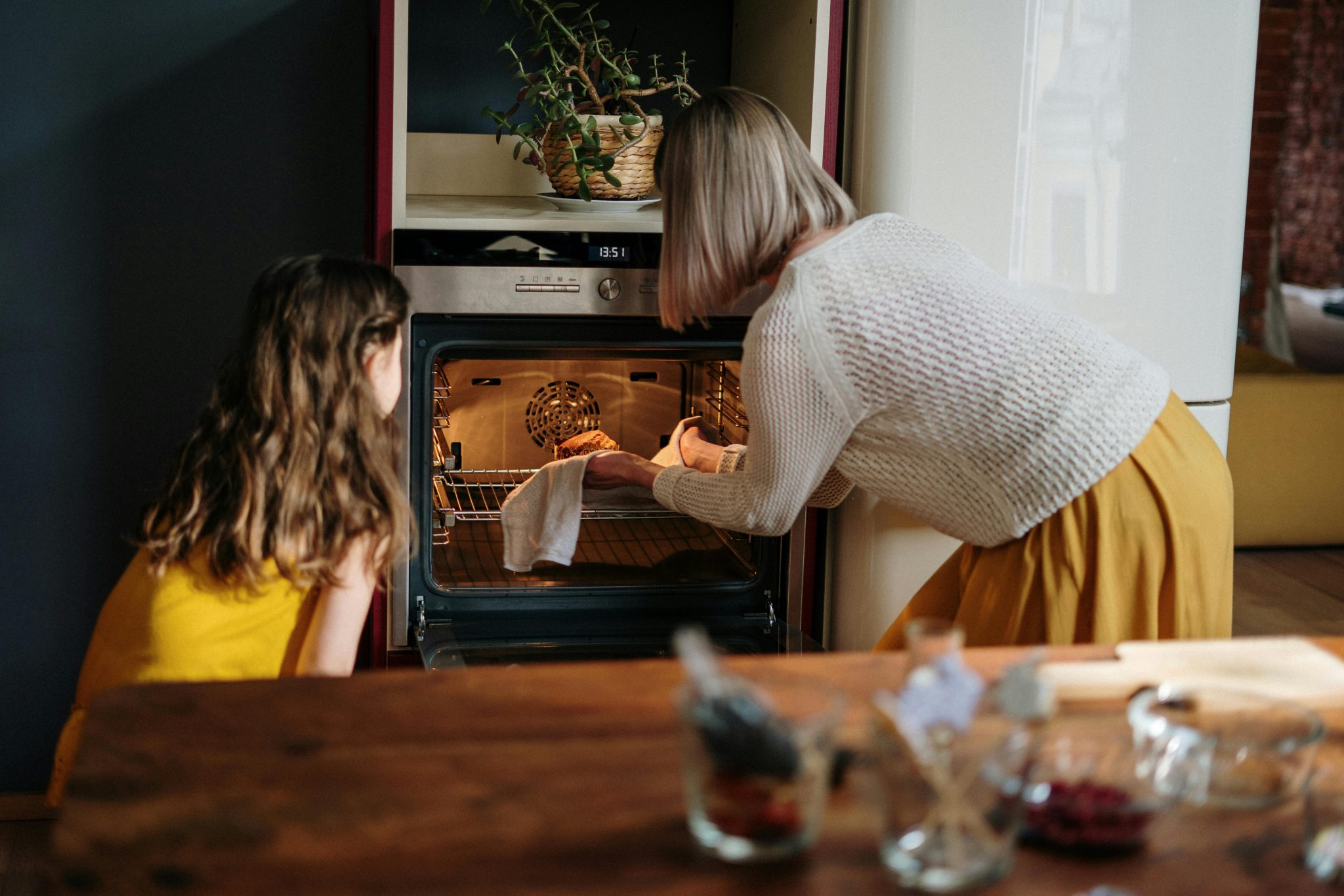 Home A mother and daughter baking a cake in a cozy kitchen setting, enhancing family time.